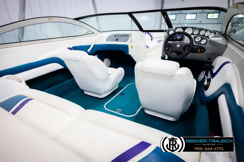 Slide: The Image of Interior of a 1997 Celebrity 190 boat with white and blue seating. - 12