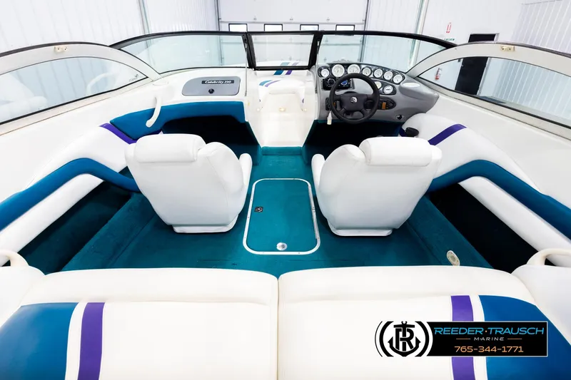 Slide: The Image of Interior of a 1997 Celebrity 190 boat with white and blue seating. - 13