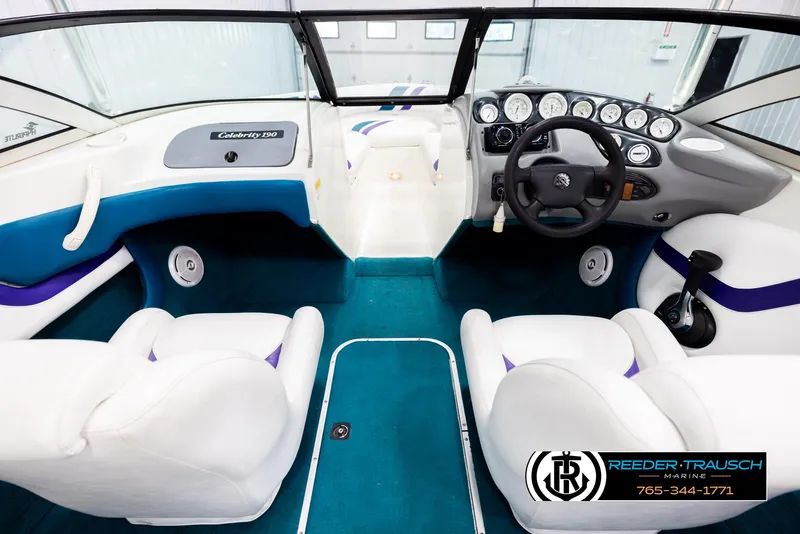 Slide: The Image of Interior of a 1997 Celebrity 190 boat with white and blue seating. - 14