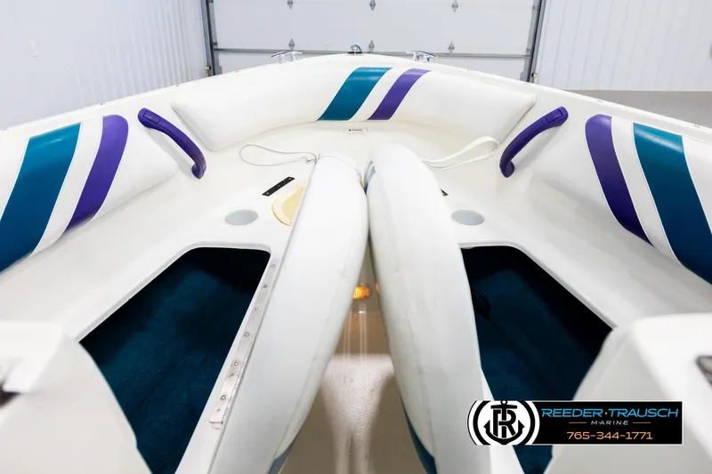 Slide: The Image of Interior of a 1997 Celebrity 190 boat with white and blue seating. - 16