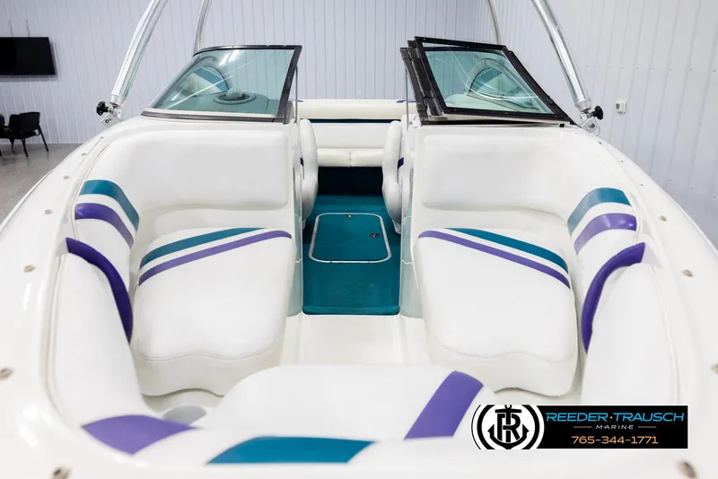 Slide: The Image of Interior of a 1997 Celebrity 190 boat with white and teal seating. - 17