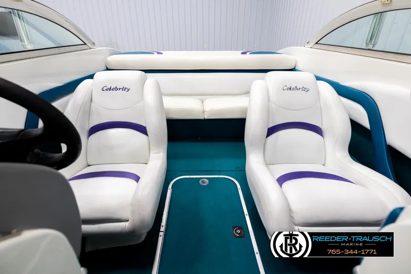 Slide: The Image of Interior of a 1997 Celebrity 190 boat with white and purple seating. - 18