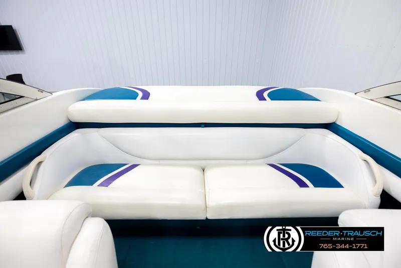 Slide: The Image of 1997 Celebrity 190 boat interior with white and blue seating, Reeder-Trausch Marine logo. - 19