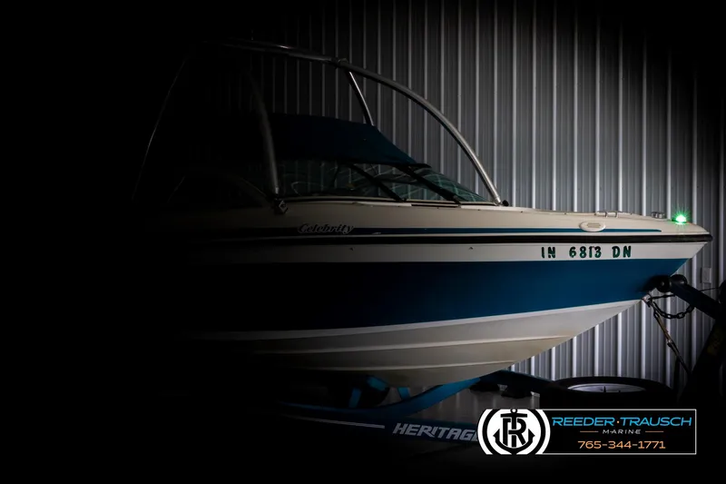 Slide: The Image of 1997 Celebrity 190 boat in storage, partially illuminated, with visible registration number. - 4