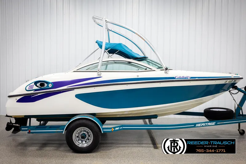 Slide: The Image of 1997 Celebrity 190 boat on trailer, blue and white design, displayed indoors. - 5