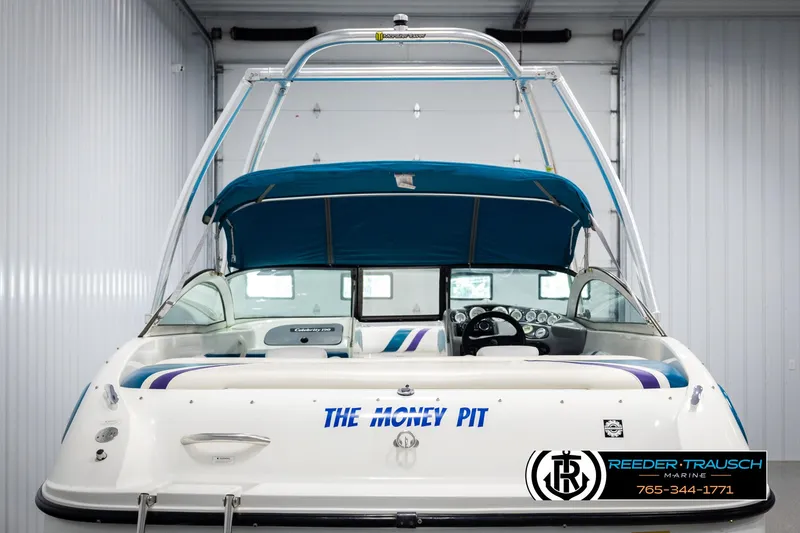 Slide: The Image of 1997 Celebrity 190 boat with blue canopy, labeled "The Money Pit," in a garage setting. - 7