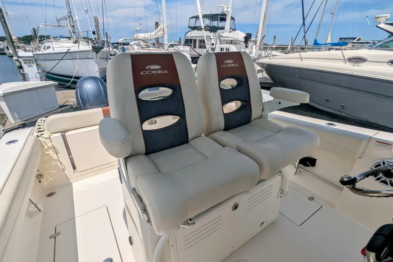 Slide: The Image of 2023 Cobia 280 Center Console boat with dual seats at marina. - 10