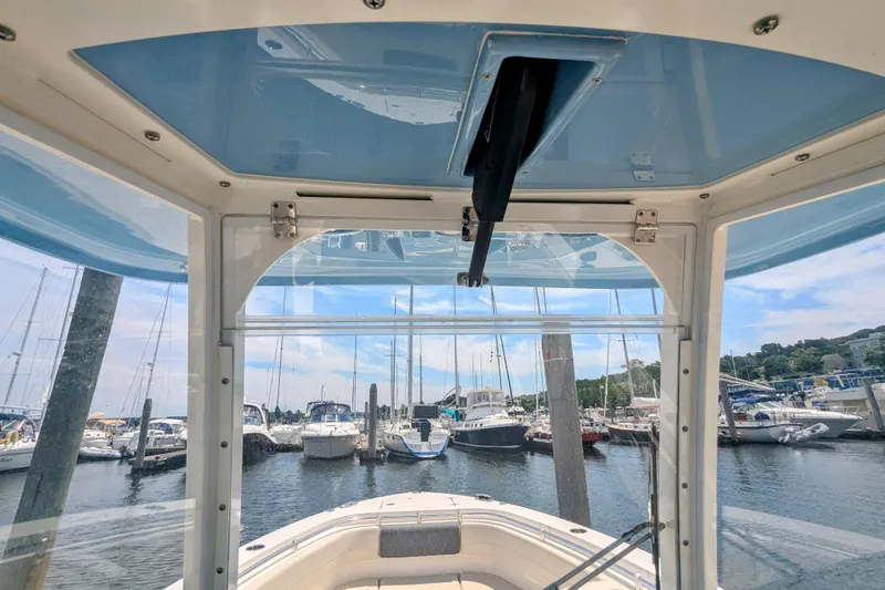Slide: The Image of 2023 Cobia 280 Center Console boat view from helm, docked at marina. - 13