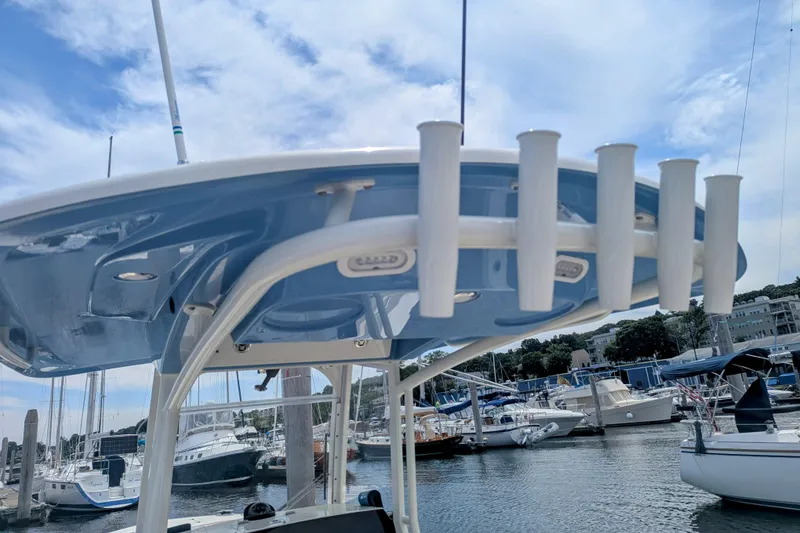 Slide: The Image of 2023 Cobia 280 Center Console boat with rod holders, docked in a marina. - 14