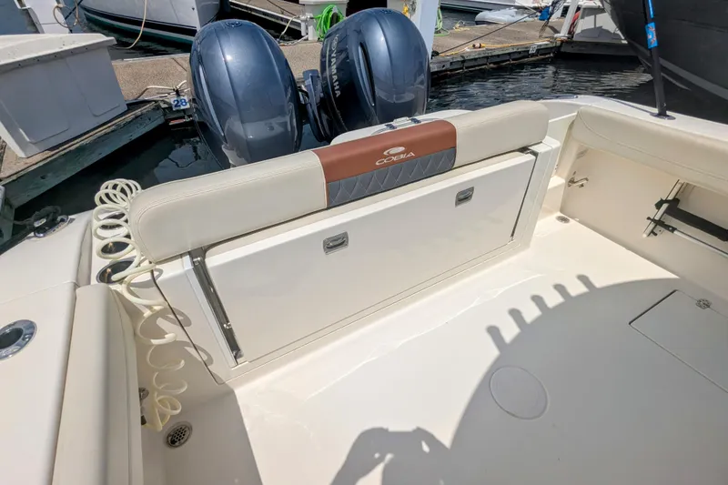 Slide: The Image of 2023 Cobia 280 Center Console boat with dual Yamaha engines at a marina. - 17