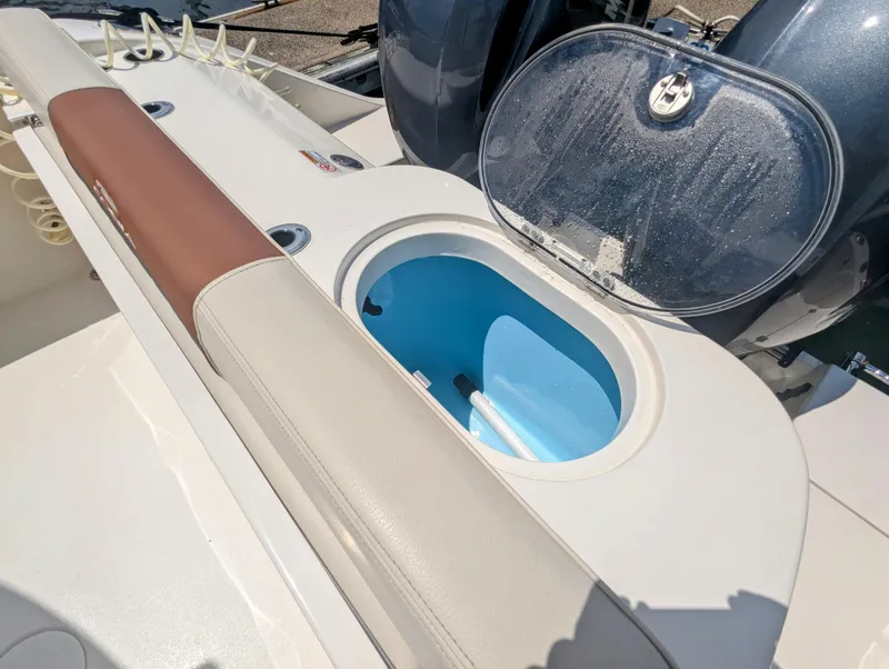 Slide: The Image of 2023 Cobia 280 Center Console boat with open storage compartment and cushioned seating. - 18