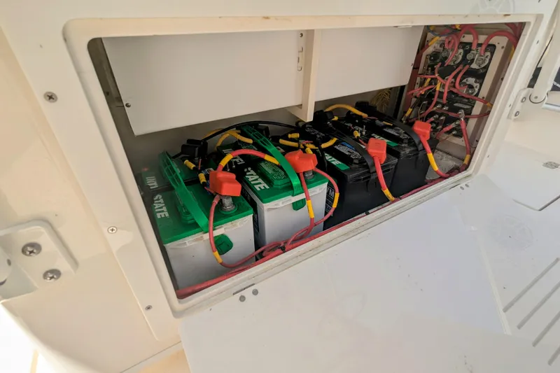 Slide: The Image of 2023 Cobia 280 Center Console battery compartment with multiple batteries and wiring. - 29