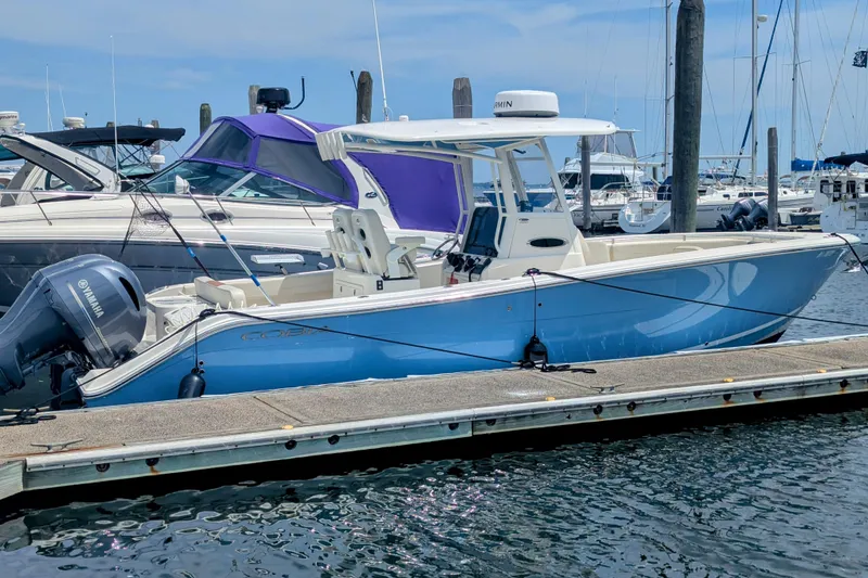Slide: The Image of 2023 Cobia 280 Center Console boat docked at marina with Yamaha engine. - 3