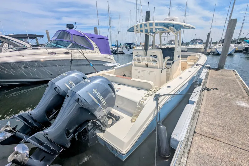 Slide: The Image of 2023 Cobia 280 Center Console boat docked with twin Yamaha engines. - 4