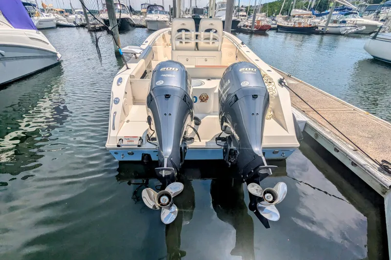 Slide: The Image of 2023 Cobia 280 Center Console boat with twin Yamaha engines docked in marina. - 5