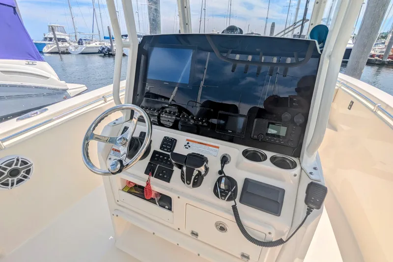 Slide: The Image of 2023 Cobia 280 Center Console helm with steering wheel and navigation equipment. - 8