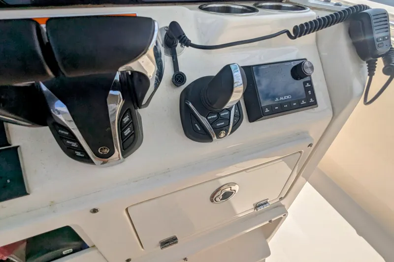 Slide: The Image of Control panel of 2023 Cobia 280 Center Console boat with audio system and throttle controls. - 9