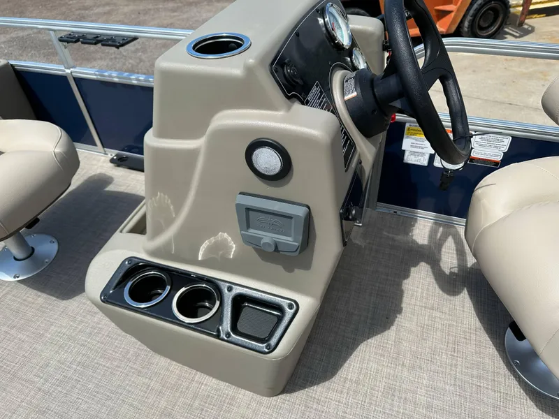 Slide: The Image of 2025 Sun Tracker Bass Buggy 18 DLX boat console with steering wheel and cup holders. - 13