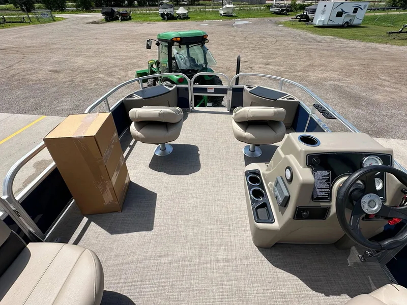 Slide: The Image of 2025 Sun Tracker Bass Buggy 18 DLX pontoon boat interior with seating and steering console. - 9
