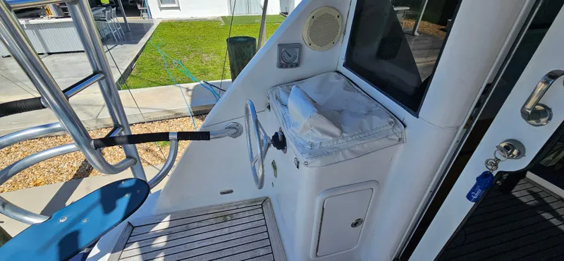 Slide: The Image of 2004 Riviera 58 Enclosed Flybridge helm station with steering wheel and controls. - 23