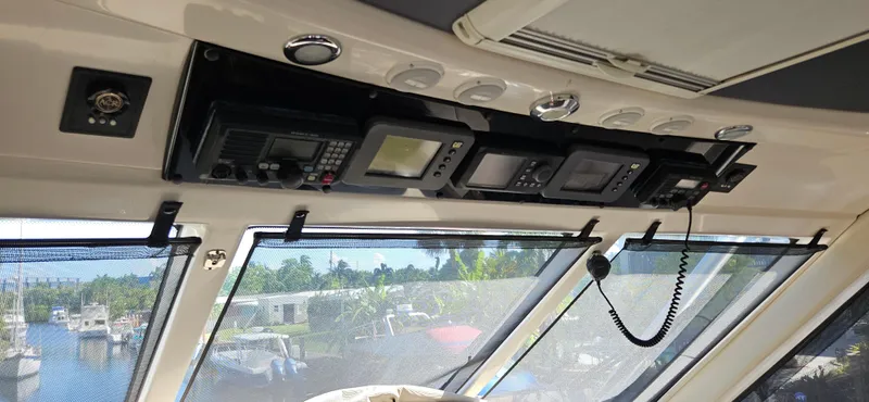 Slide: The Image of Interior view of 2004 Riviera 58 Enclosed Flybridge with navigation equipment and waterfront background. - 32