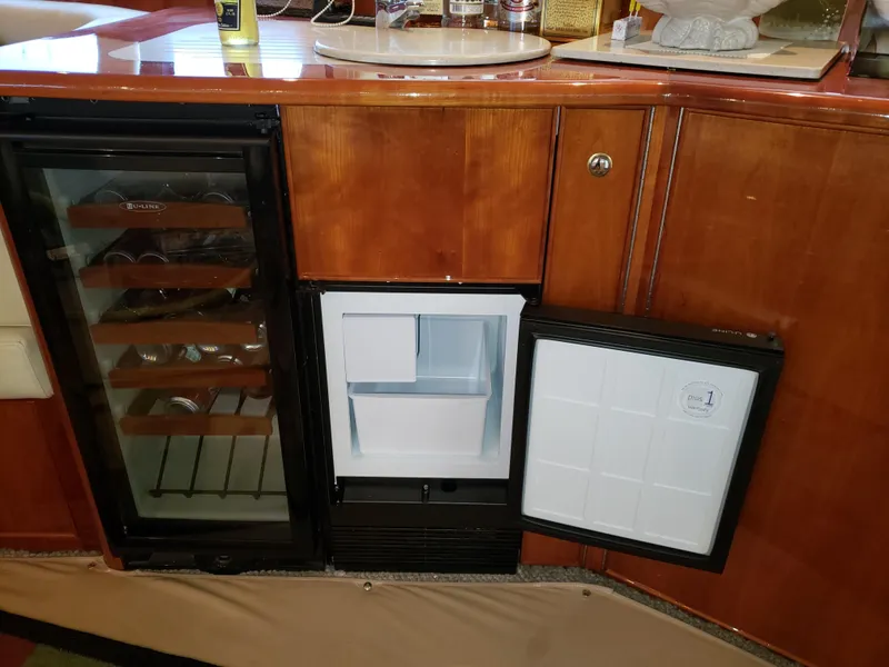 Slide: The Image of 2004 Riviera 58 Enclosed Flybridge interior with wine cooler and mini fridge. - 42