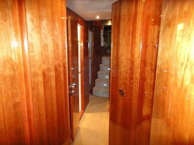 Slide: The Image of Interior hallway of 2004 Riviera 58 Enclosed Flybridge yacht with polished wooden walls. - 48