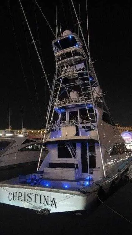 Slide: The Image of 2004 Riviera 58 Enclosed Flybridge yacht at night with blue lights. - 5