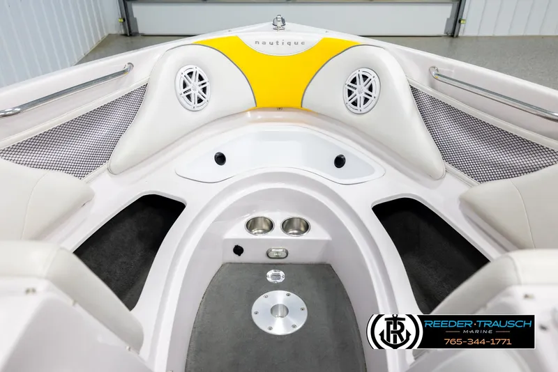 Slide: The Image of 2005 Correct Craft 226 Nautique boat interior with white and yellow seating, cup holders, and speakers. - 15