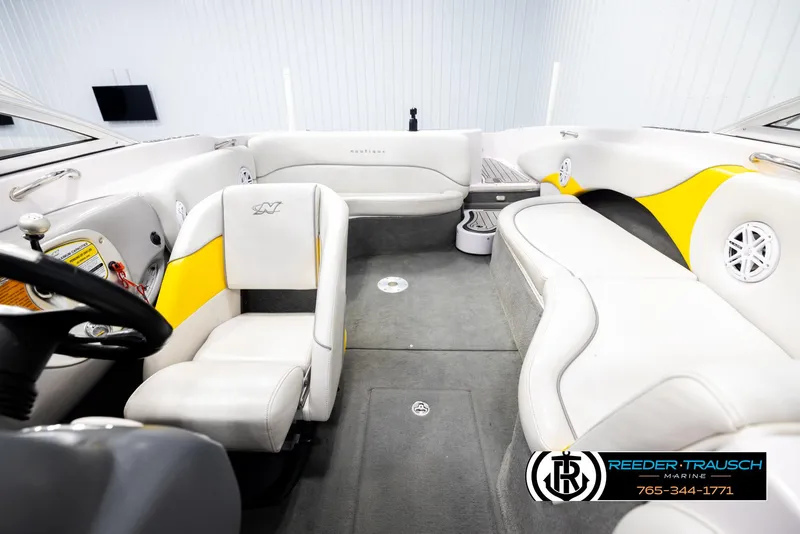Slide: The Image of 2005 Correct Craft 226 Nautique interior with white and yellow seating, steering wheel, and carpeted floor. - 17