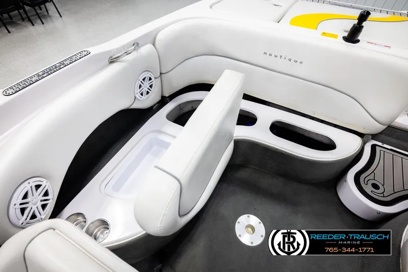 Slide: The Image of 2005 Correct Craft 226 Nautique boat interior with white seating and cup holders. - 21