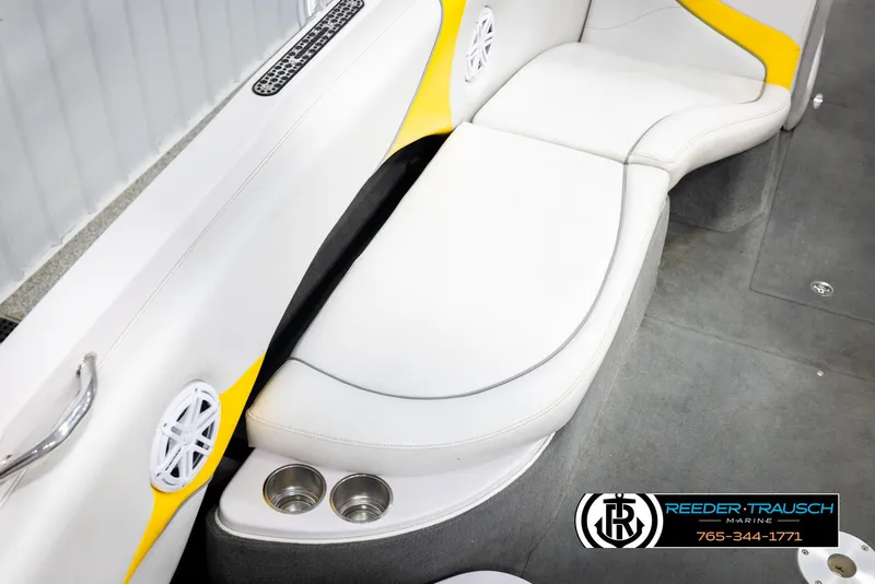 Slide: The Image of 2005 Correct Craft 226 Natique boat interior with white and yellow seating, cup holders, and speakers. - 24