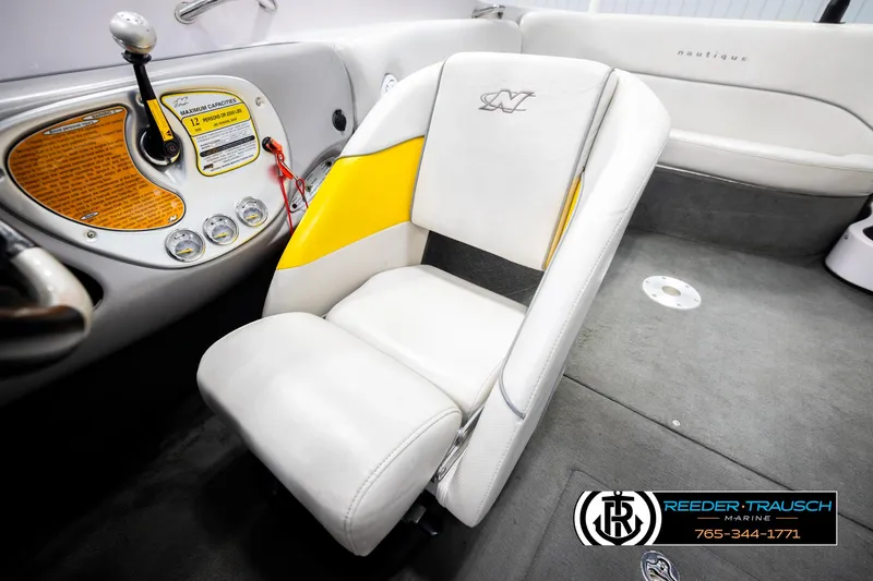 Slide: The Image of 2005 Correct Craft 226 Nautique boat interior with white and yellow seating, dashboard controls. - 26