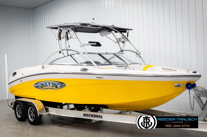 Slide: The Image of 2005 Correct Craft 226 Natique boat in bright yellow on a trailer indoors. - 3