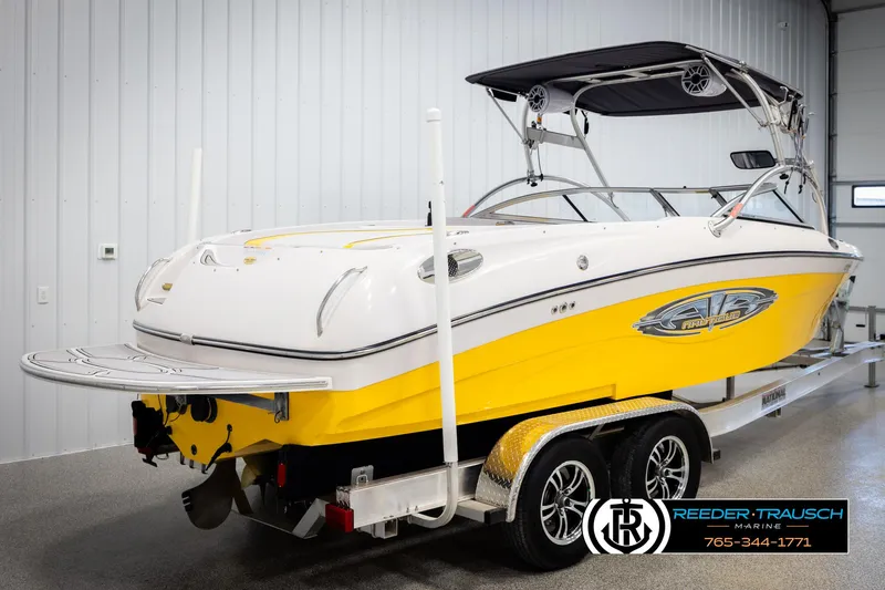 Slide: The Image of 2005 Correct Craft 226 Nautique boat, yellow and white, on trailer in indoor storage. - 5