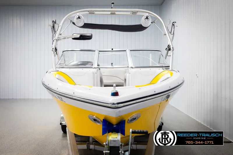 Slide: The Image of 2005 Correct Craft 226 Natique boat with yellow hull in showroom. - 7