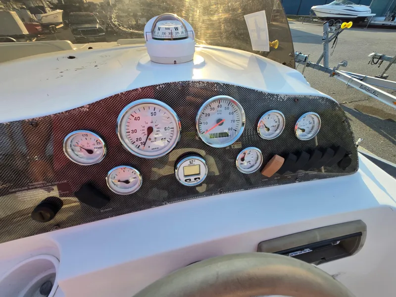 Slide: The Image of 2002 Glastron DX 215 boat dashboard with gauges and compass in sunlight. - 5
