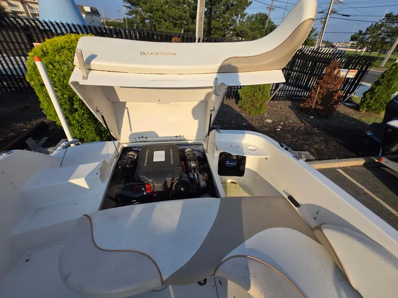 Slide: The Image of 2002 Glastron DX 215 boat engine compartment with open hatch, showcasing interior components. - 9