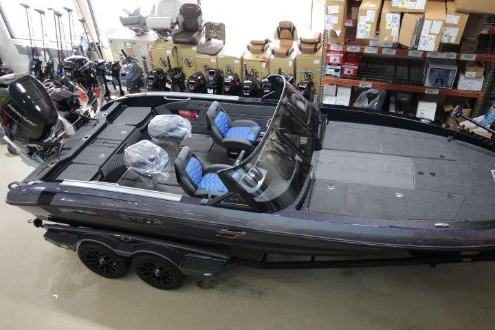 Slide: The Image of 2025 Vexus DVX22S boat in showroom, featuring sleek design and blue-accented seats. - 11
