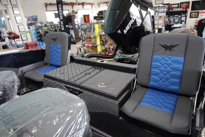 Slide: The Image of 2025 Vexus DVX22S boat interior with blue and gray seating in showroom. - 13