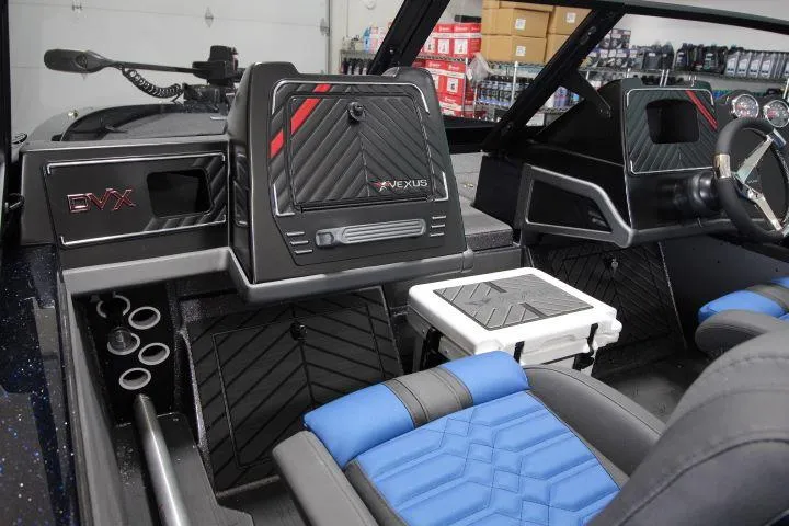 Slide: The Image of 2025 Vexus DVX22S boat interior with modern dashboard, blue seats, and storage compartments. - 14
