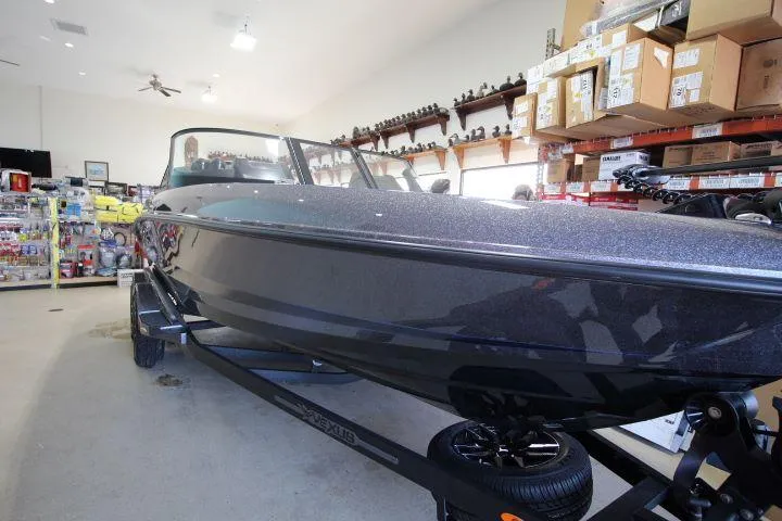 Slide: The Image of 2025 Vexus DVX22S boat in showroom, surrounded by shelves and products. - 3
