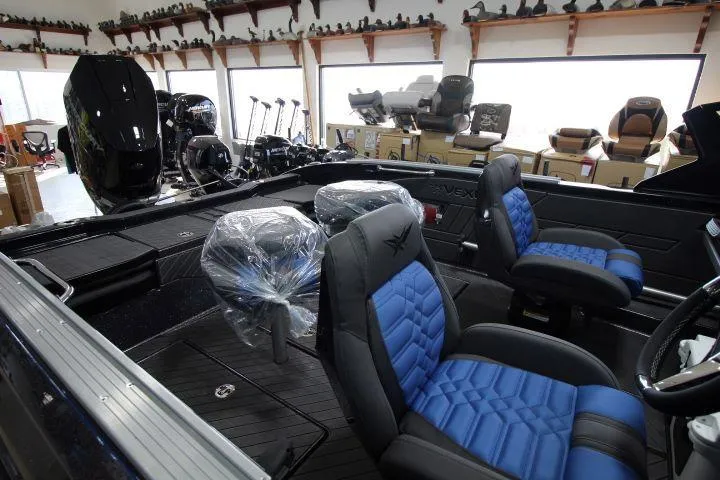 Slide: The Image of 2025 Vexus DVX22S boat interior with blue and black seating in showroom. - 4