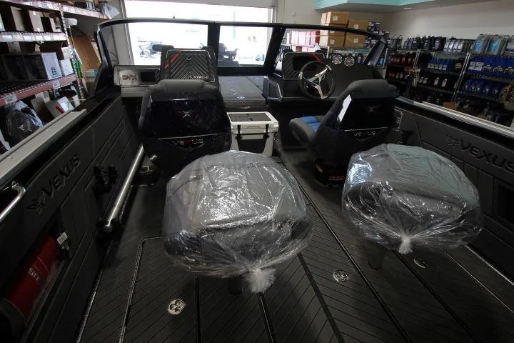 Slide: The Image of 2025 Vexus DVX22S boat interior with covered seats in a showroom. - 7