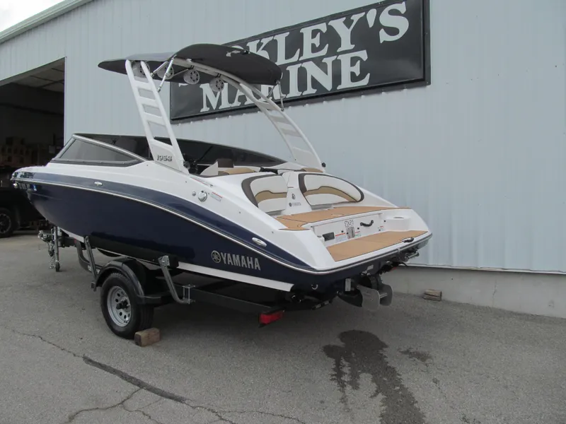 Slide: The Image of 2022 Yamaha Boats 195S in blue and white, parked outside a marine shop. - 2
