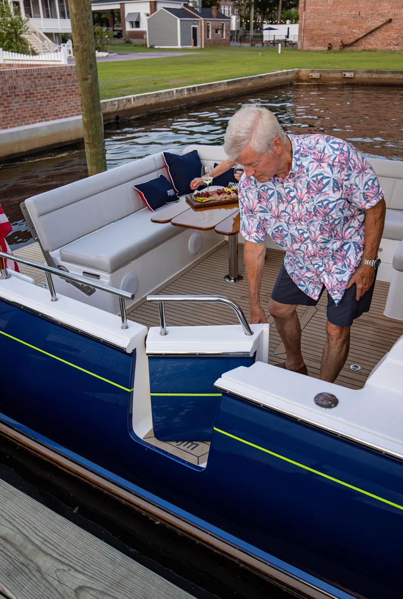 Slide: The Image of Man boarding a 2025 MJM 42 yacht, featuring a stylish deck and seating area. - 26