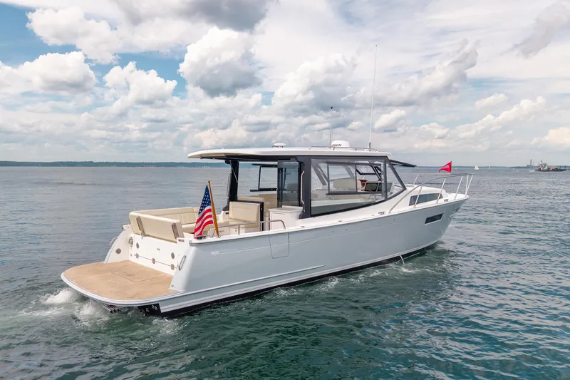 Slide: The Image of 2025 MJM 42 yacht cruising on open water under a partly cloudy sky. - 4