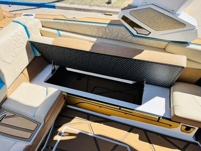Slide: The Image of 2024 Nautique G25 Paragon boat interior with open storage compartment and luxurious seating. - 26