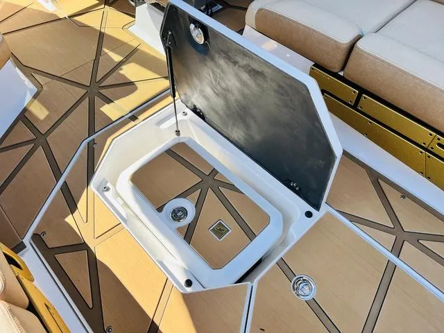 Slide: The Image of 2024 Nautique G25 Paragon boat storage compartment with open lid, featuring sleek design and seating. - 46