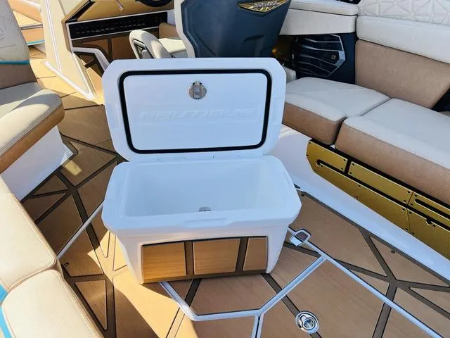 Slide: The Image of 2024 Nautique G25 Paragon interior with open cooler and luxurious seating. - 47